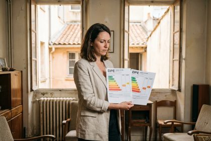 Femme comparant deux diagnostics de performance énergétique DPE dans un appartement ancien à Marseille avec fenêtres à simple vitrage