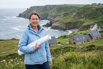 Femme en veste bleue sur la côte bretonne avec plans d'architecture